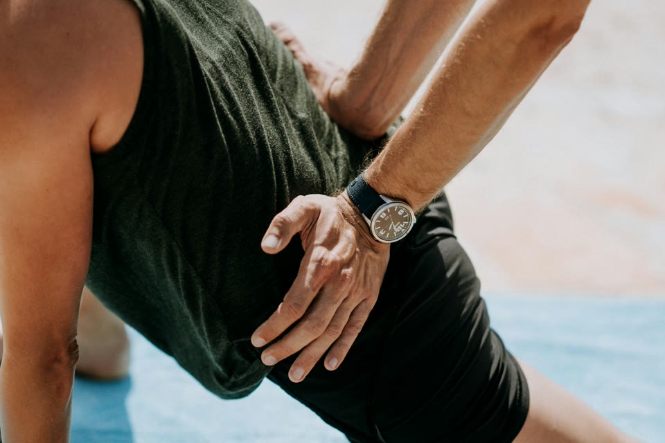 Hands supporting a person during a stretching exercise