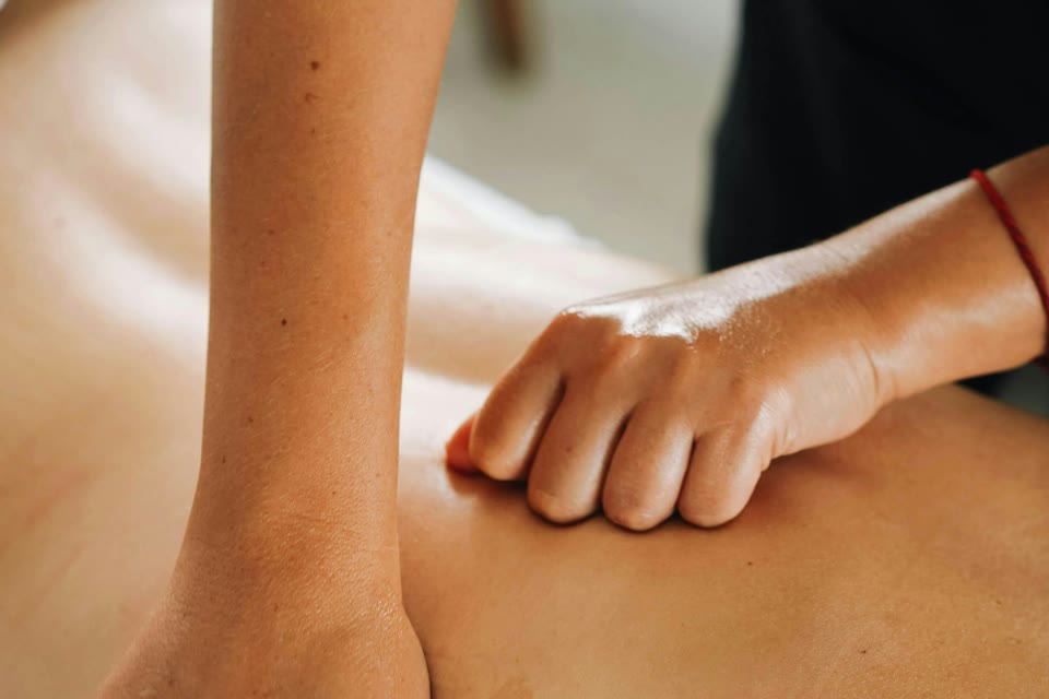 Massageology - Karen D'Aprile - a massage therapist working with both hands on a client's back during a treatment